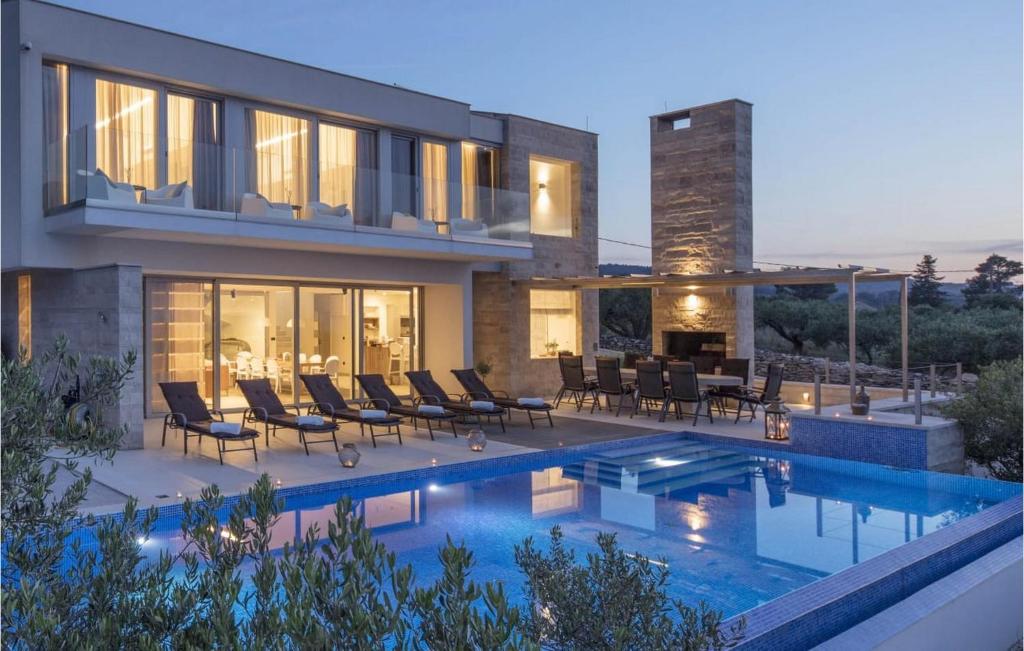 a house with a swimming pool in front of it at Villa Elegant in Splitska
