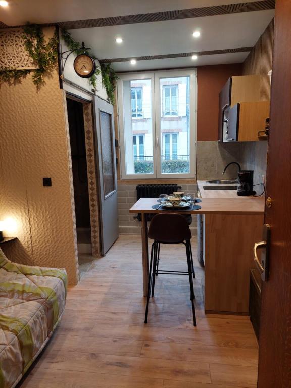 une petite cuisine avec une table dans une pièce dans l'établissement Studette, au Mans