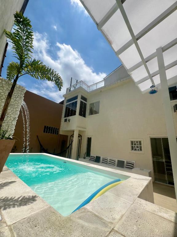a swimming pool in front of a house at Casa com piscina, churrasqueira e terraço com vista pro mar! in Mangaratiba