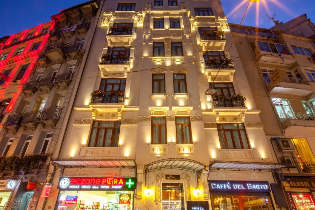 Un edificio alto y blanco con luces. en Hotel Pera Parma, en Estambul