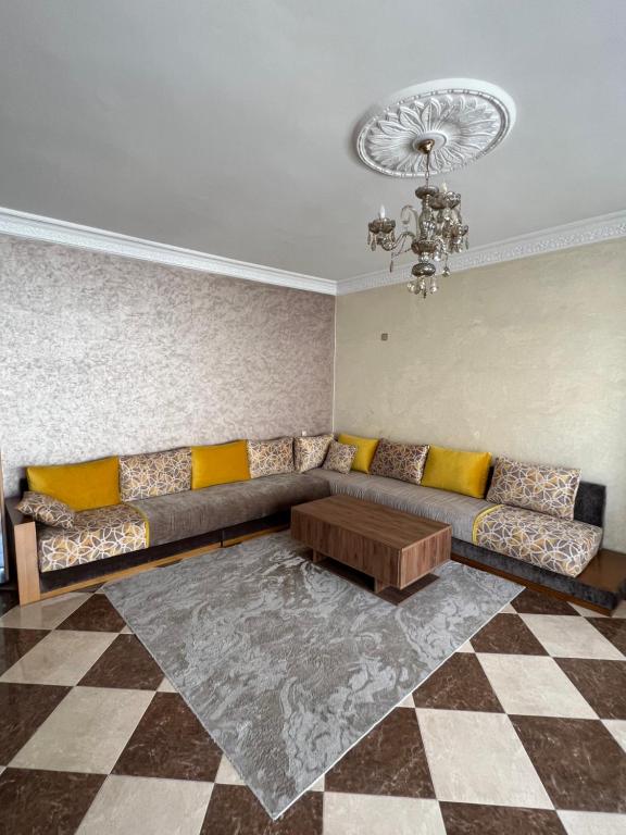 a living room with a couch and a table at Appartement spacieux avec terrasse à 10 minutes du centre in Tangier