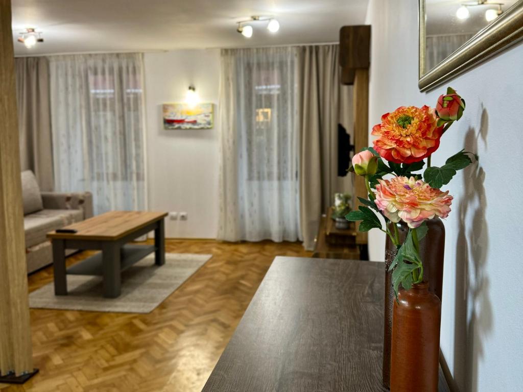 a living room with a vase of flowers on a table at Blancris Studio in Braşov