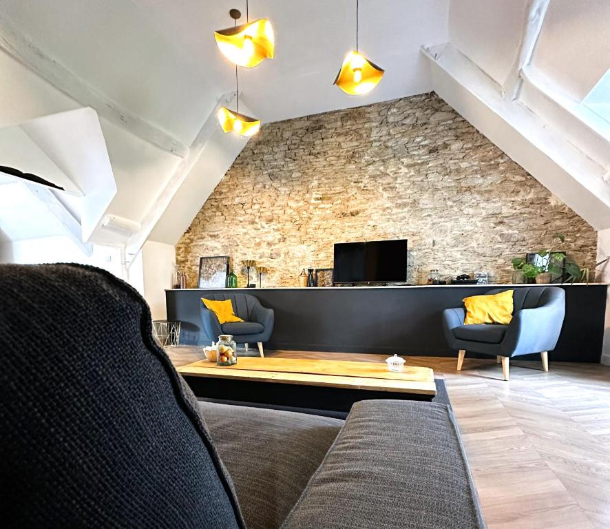 un salon avec un canapé et un mur en pierre dans l'établissement La Casa D or, à Guilliers