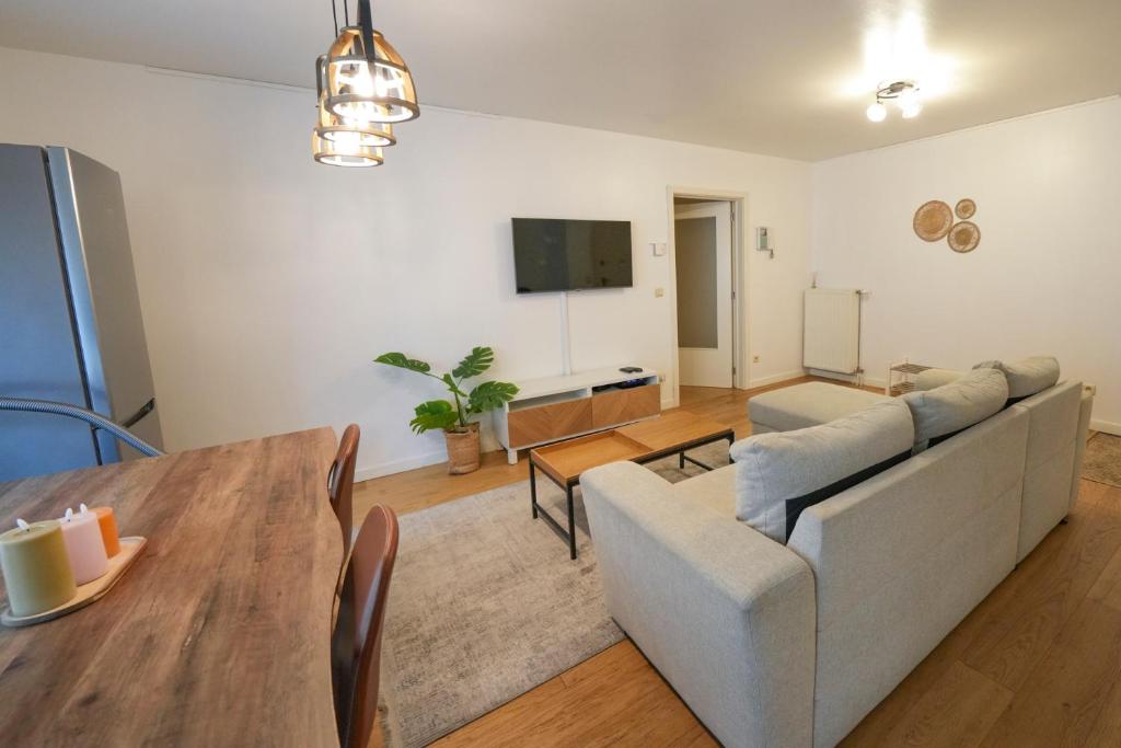 a living room with a couch and a table at Cocon tout chaud - Pour couple avec ou sans bébé in Brussels