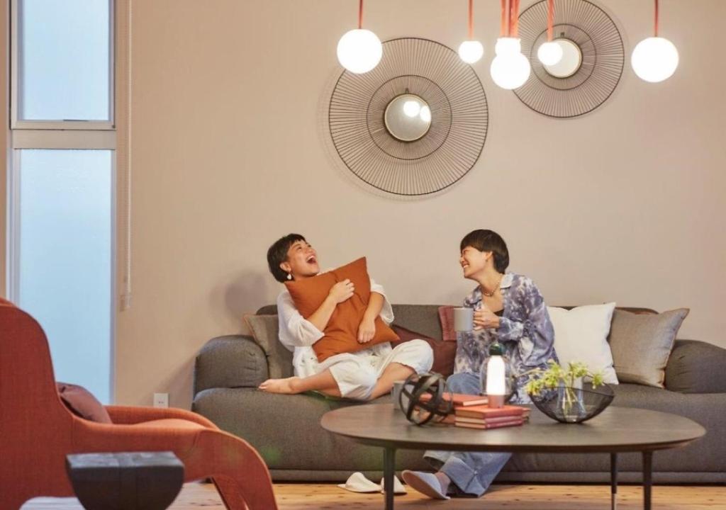 two people sitting on a couch in a living room at Villa Oloo - Vacation STAY 44072v in Karimata