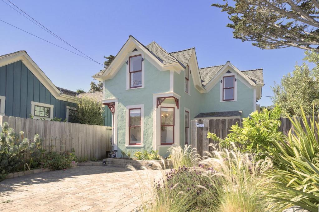 a green house with a fence at 3943 Rad Beach House home in Pacific Grove