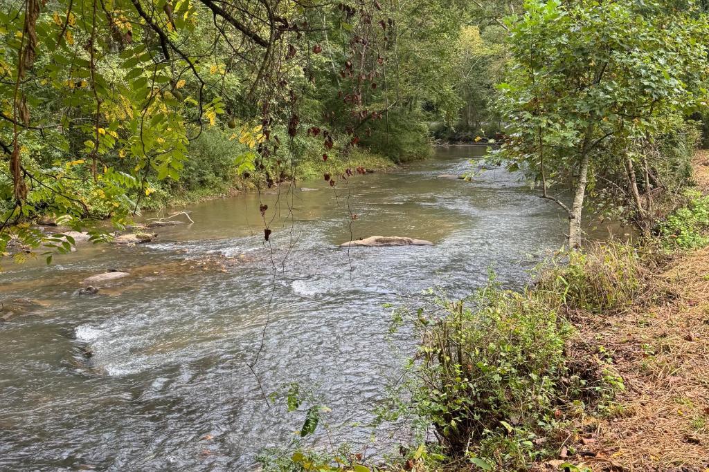 Un río con rocas en el medio. en River Fishing Cabin, en Lakemont