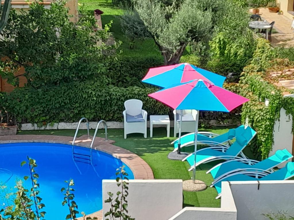 eine Terrasse mit Stühlen und einem Sonnenschirm sowie ein Pool in der Unterkunft Villa Marina in Orosei