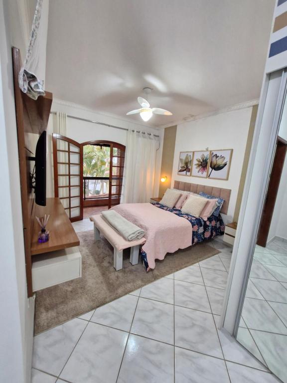 a bedroom with a king sized bed and a table at Casa Maravilhosa in Praia Grande