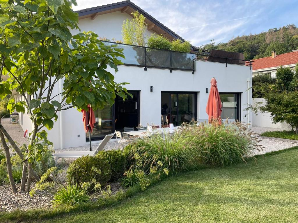 une maison blanche avec un toit en verre et une cour dans l'établissement Logement avec hammam - 130 m2 et jardin - Terre de Cocon, à Perrignier