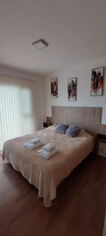 Un dormitorio con una cama grande con toallas. en Kattegat, en Puerto Madryn