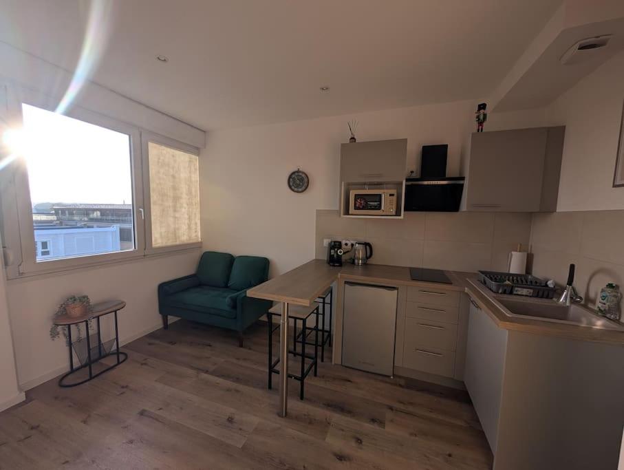 a kitchen with a couch and a table in a room at écrin de lumière à 10 min de l'hypercentre in Strasbourg