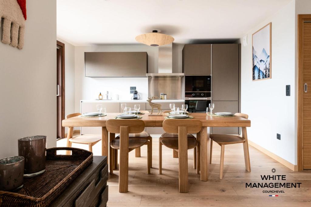 - une cuisine avec une table à manger en bois et des chaises dans l'établissement Résidence Les Glaciers - Superbe duplex vue Vallée à Courchevel 1650 MAE-5251, à Courchevel