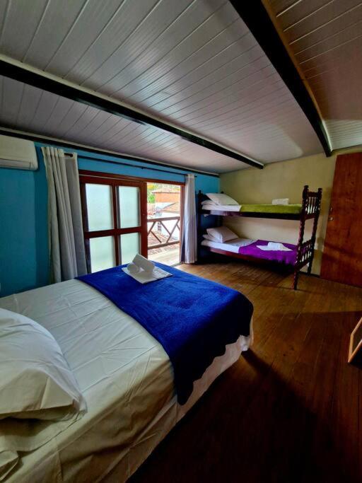 una camera da letto con un letto in una stanza con una finestra di Apartamento duplex - 2 quartos na Pituba a Itacaré