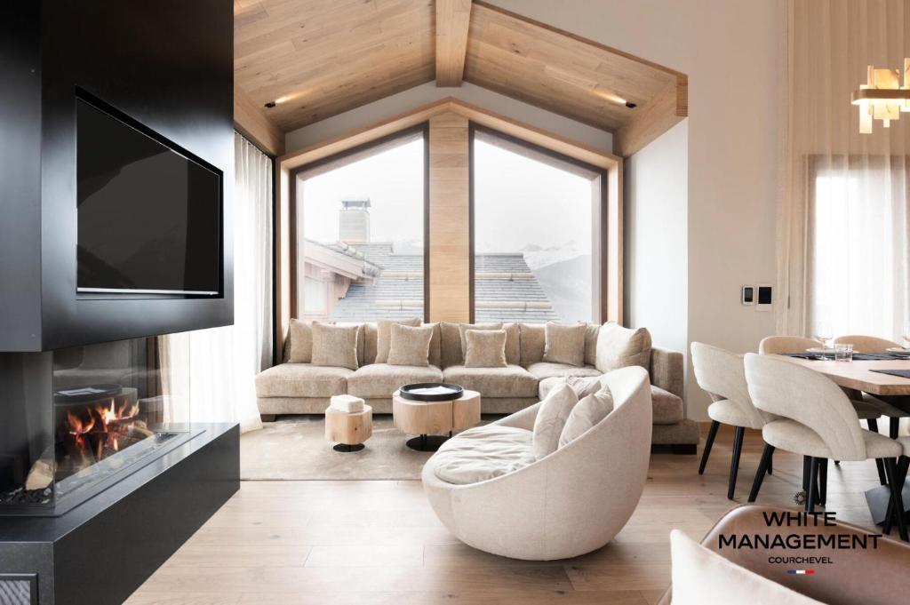 un salon avec un canapé et une cheminée dans l'établissement Résidence Les Glaciers - Chaleureux chalet contemporain à Courchevel 1650 MAE-4431, à Courchevel
