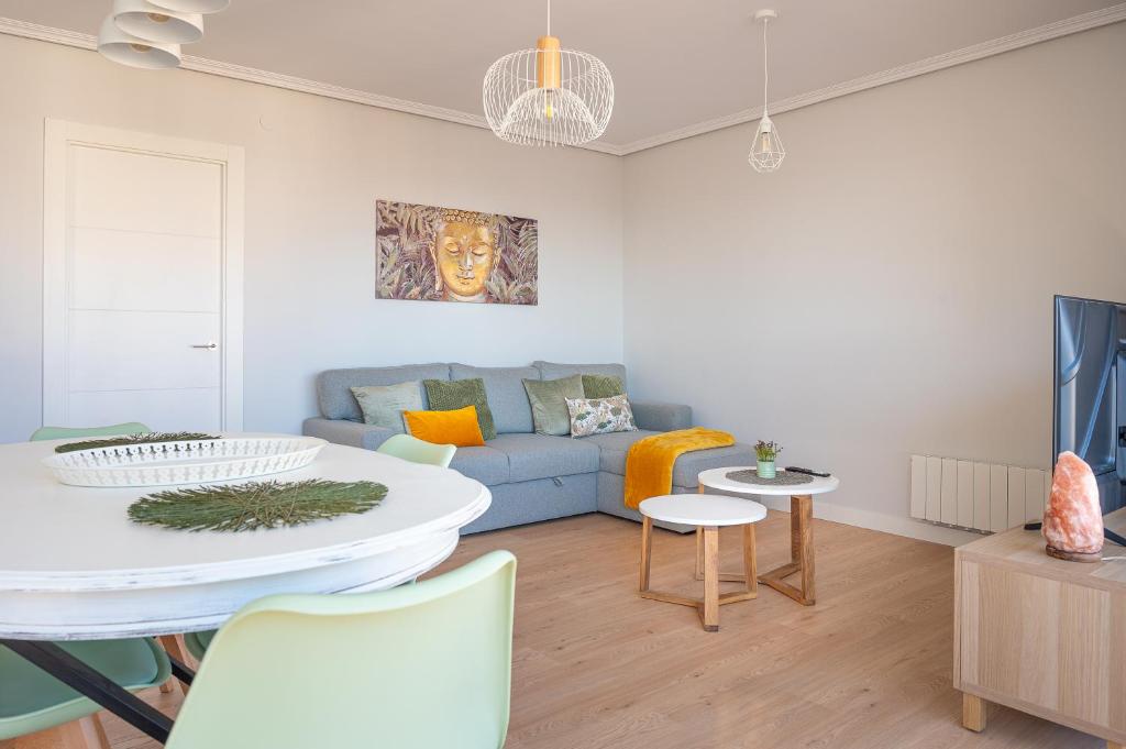 Una sala de estar con un sofá azul y una mesa. en Santander Centro I 3 Hab I Wifi I Moderno, en Santander