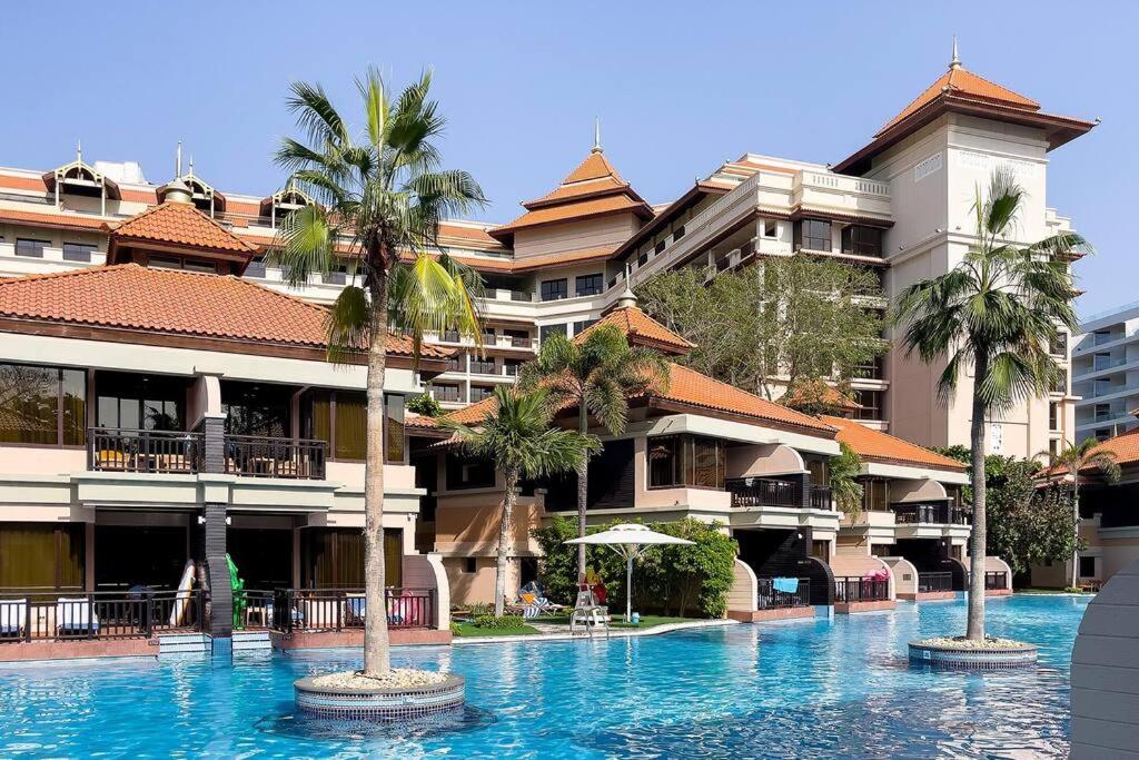 una piscina di fronte a un edificio con palme di Anantara Palm Jumeirah Studio Sea View a Dubai