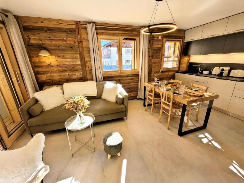 un salon avec un canapé et une table dans l'établissement Résidence Essentiel - Appartement de charme au centre du village MAE-1731, aux Gets