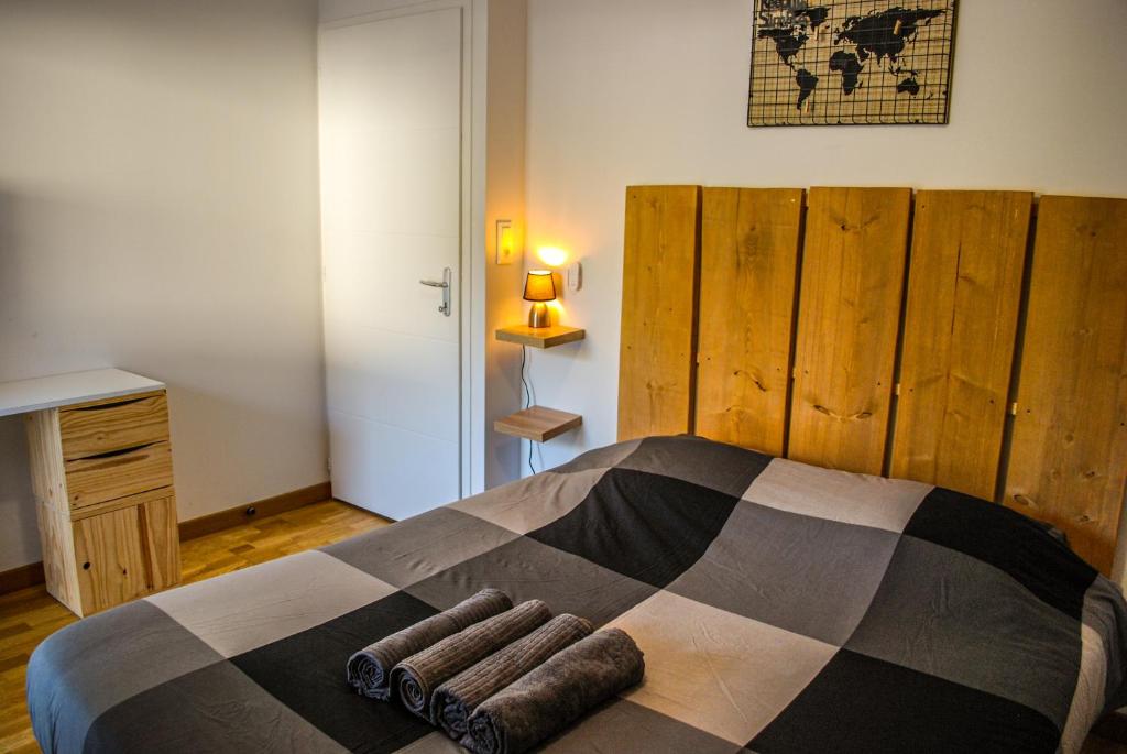 une chambre avec un lit avec une couverture dessus dans l'établissement “L’Escapade”, entre lac et montagne, à Saint-Alban