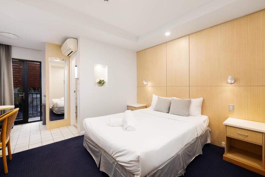 a hotel room with a large bed and a desk at Asraport Motel in Brisbane