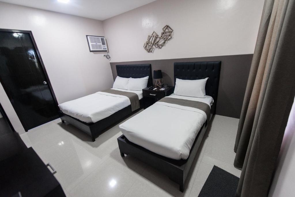 Postel nebo postele na pokoji v ubytování Bumble V Subic Hotel