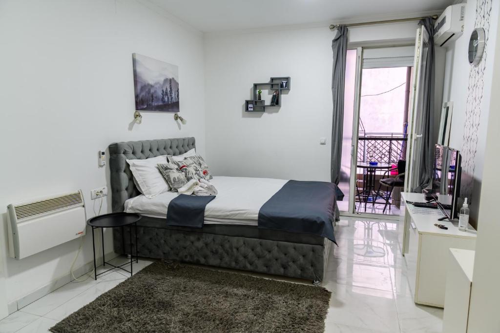 een slaapkamer met een bed in de hoek van een kamer bij Natalie's Inn in Belgrado