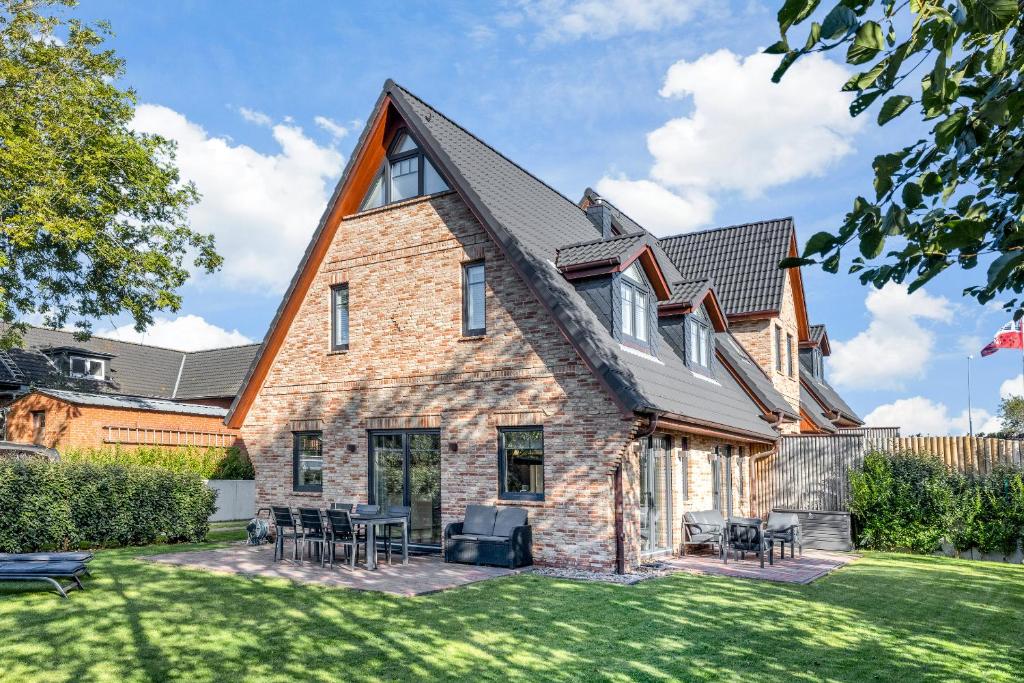 una casa con techo de gambrel y césped en Lieblings Hues, en Tinnum