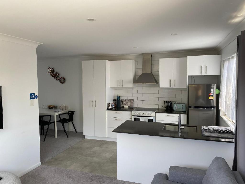 a kitchen with white cabinets and a counter top at 2BD Family or Couple Guesthouse Upstairs near Turf club, HOTA in Bundall in Gold Coast