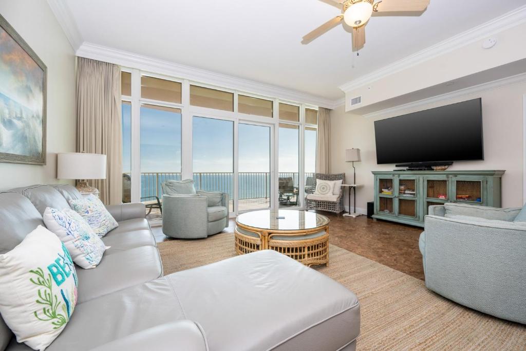 a living room with a couch and a flat screen tv at Phoenix Gulf Shores 803 condo in Gulf Shores