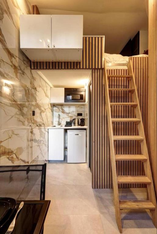 une chambre avec un escalier et une cuisine équipée d'un réfrigérateur. dans l'établissement Cosy room inside Batignolles - L60, à Paris