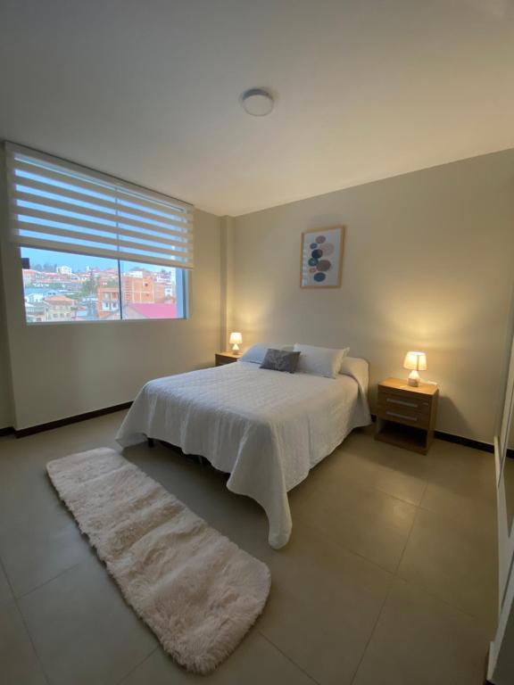 スクレにあるDepartamento en barrio Petroleroの白いベッドと窓のある寝室