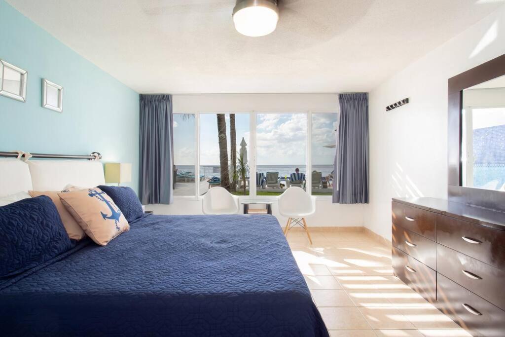 una camera con un letto blu e una grande finestra di Inspiring and relaxing sea view condo a Cozumel