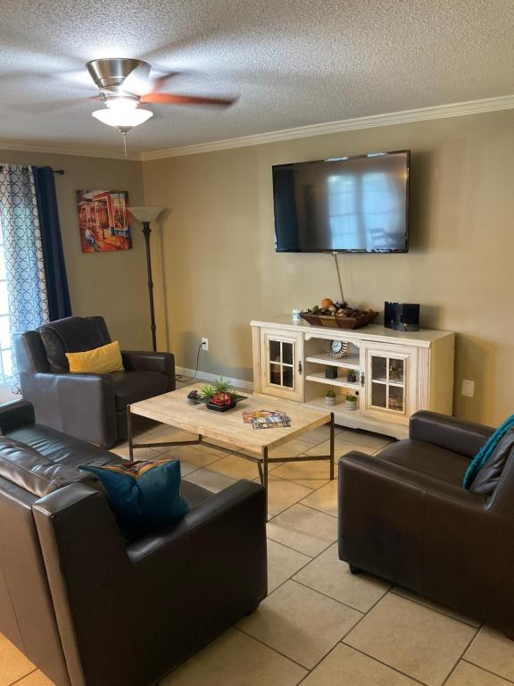 a living room with couches and a flat screen tv at 3 bedroom Cozy vacation rental near airport in Kenner