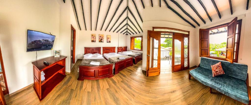 a living room with two beds and a couch at Hotel Campestre Villa Salome in Quimbaya
