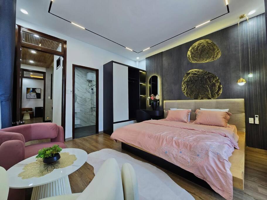 a bedroom with a pink bed and a table at Cy sea villa 3 in Da Nang