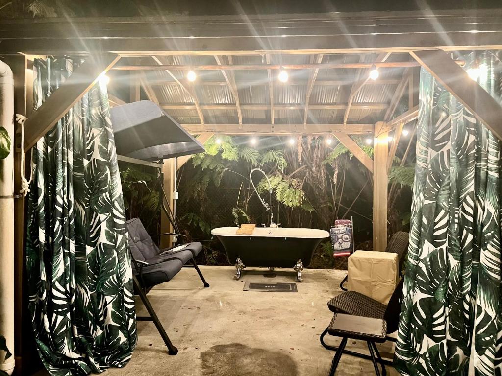 une salle de bains avec une baignoire et une fresque verte dans l'établissement Romantic Retreat, Relax at Hot-tub, Indoor & Outdoor shower, firepit, 5 min to Hawaii Volcano park, à Volcano