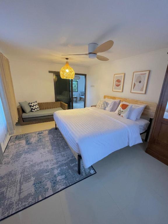a bedroom with a large bed and a couch at Kataleya Villa, Punclut 4BR in Bongkar 2