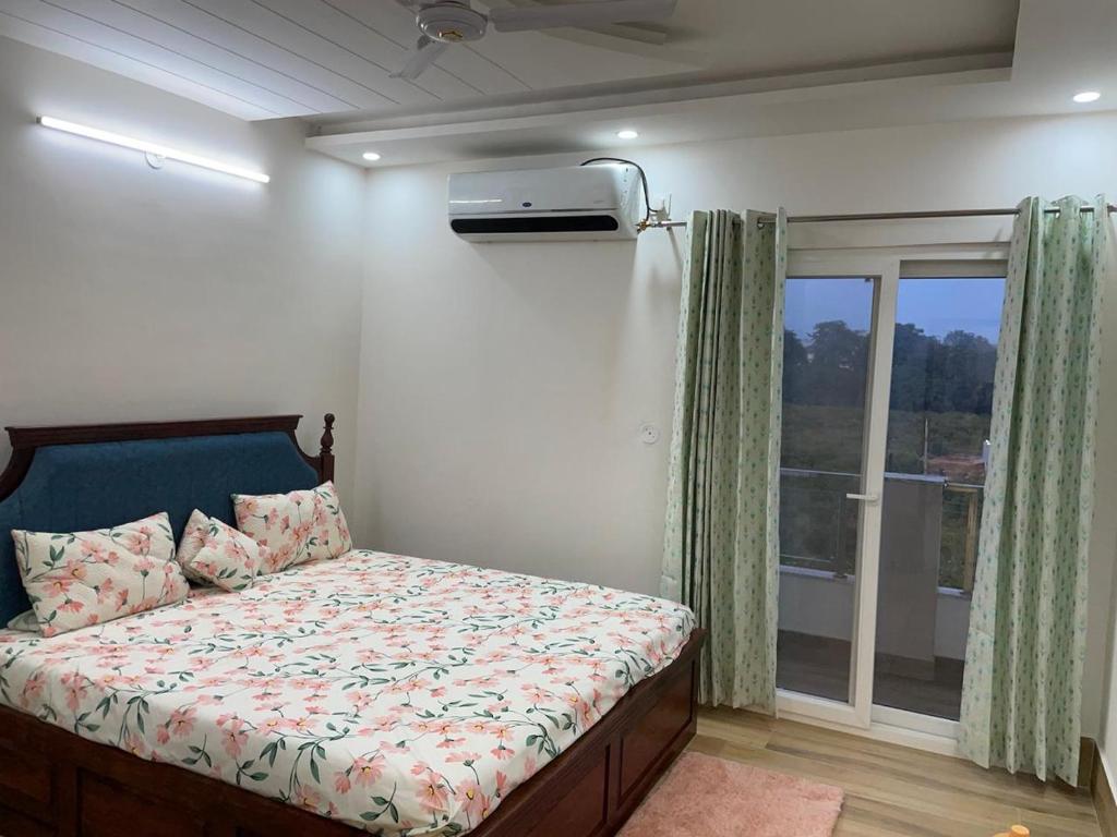 una camera da letto con un letto e una finestra di The feathers a Dehradun
