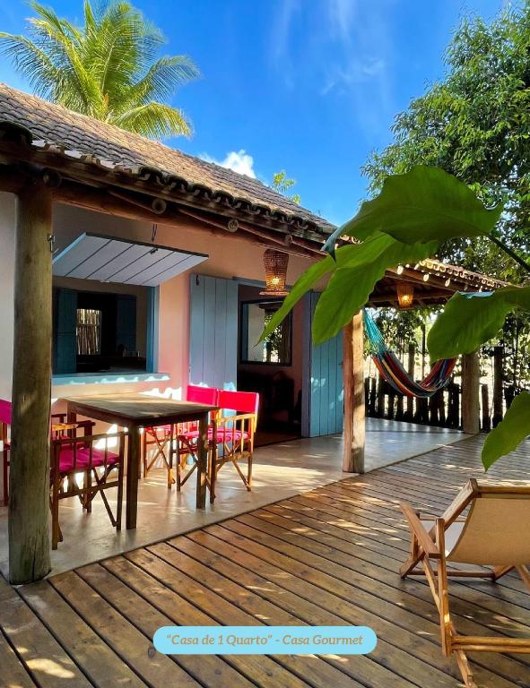 a wooden deck with a table and chairs on it at Minha Casa em Caraíva, no centro da vila in Caraíva