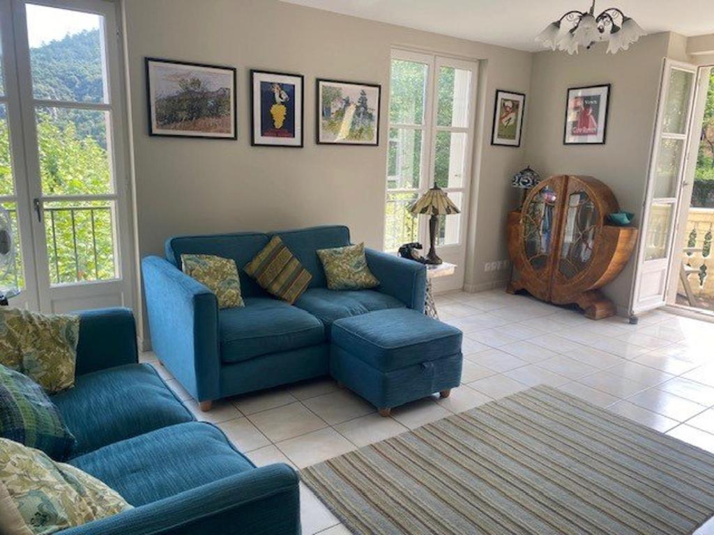 un salon avec un canapé bleu et des chaises dans l'établissement Bel F3 en centre-ville avec balcon et parking, proche cures - FR-1-703-196, à Amélie-les-Bains-Palalda