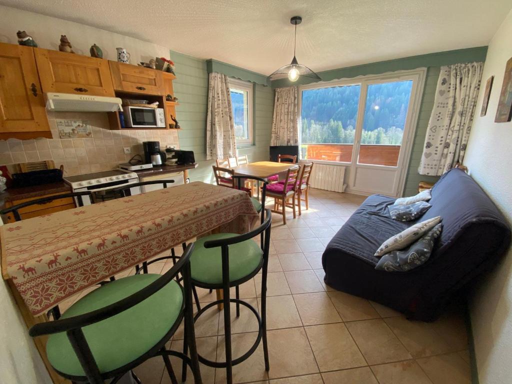 une cuisine et un salon avec une table et un canapé dans l'établissement Charmant appartement au centre du village avec balcon et parking - FR-1-692-104, à La Chapelle-dʼAbondance