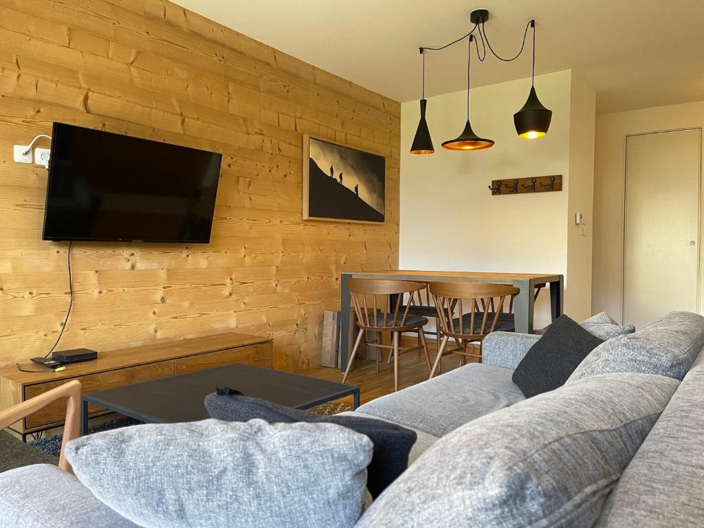 un salon avec un canapé et une télévision dans l'établissement Bel appartement, résidence neuve, parking, wifi - FR-1-624-171, à Samoëns