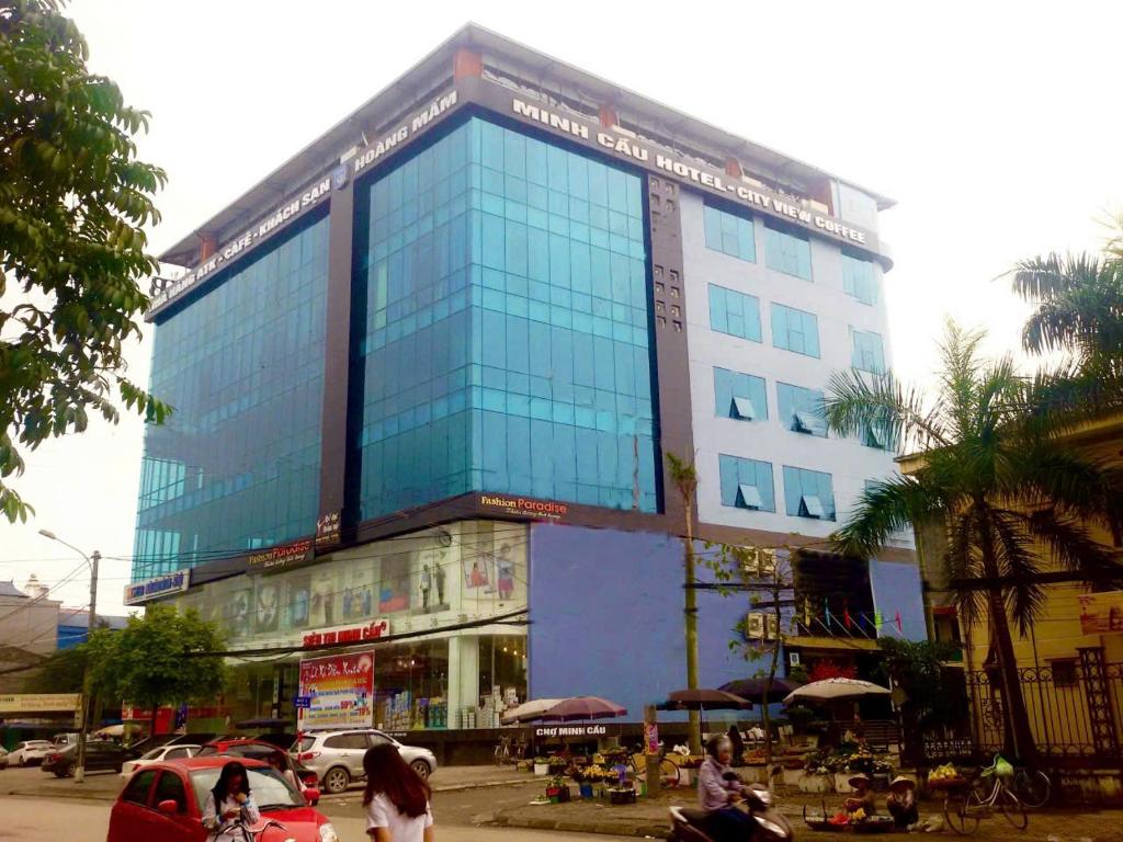 a large glass building with people in front of it at Khách Sạn Hoàng Mấm Minh Cầu - Best City view in Thái Nguyên
