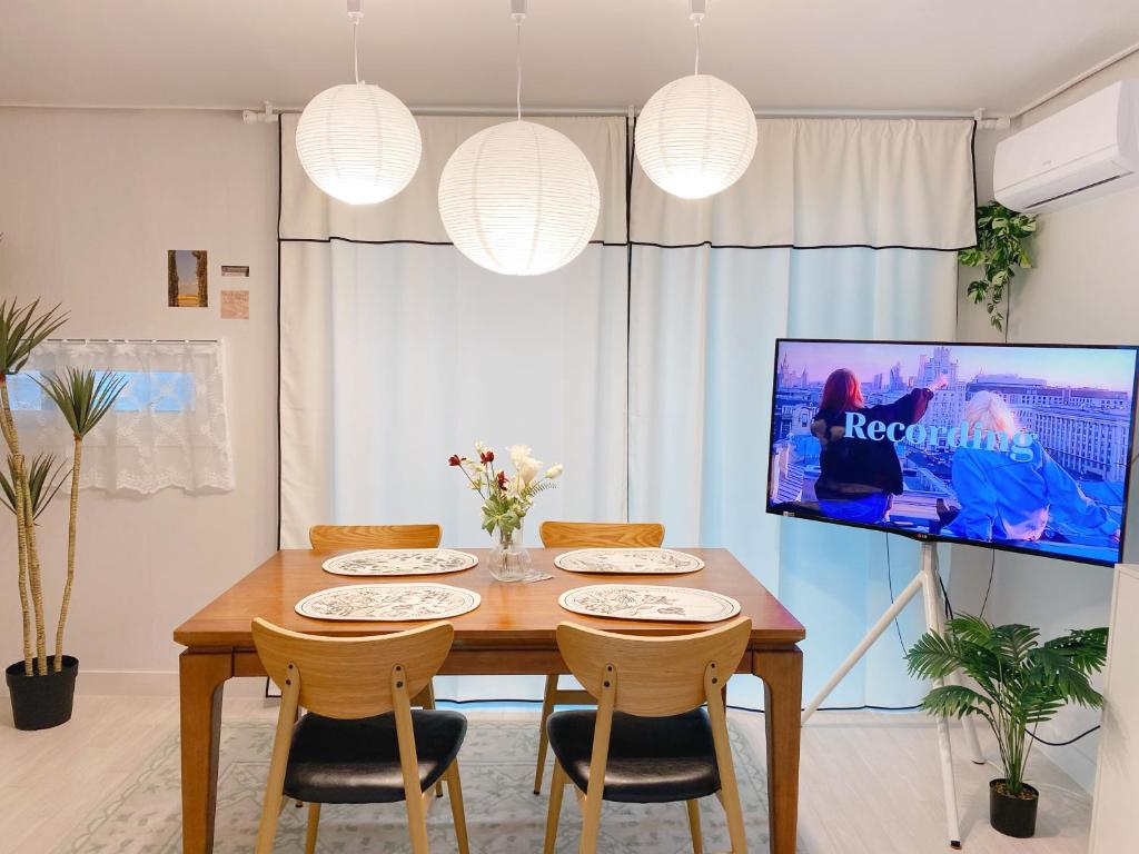 a dining room with a wooden table and chairs at Sha lala stay in Seoul