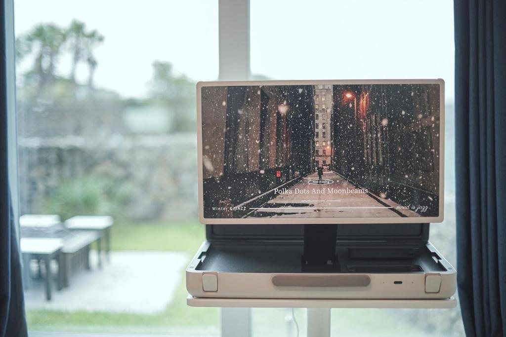a laptop computer sitting on a table next to a window at Gamseong Dorm in Jeju