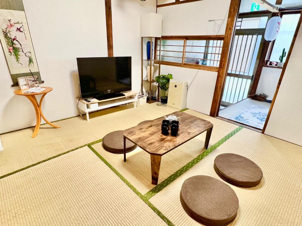 a living room with a coffee table and a tv at 9人可能 黒門市場 けんちハウス in Osaka
