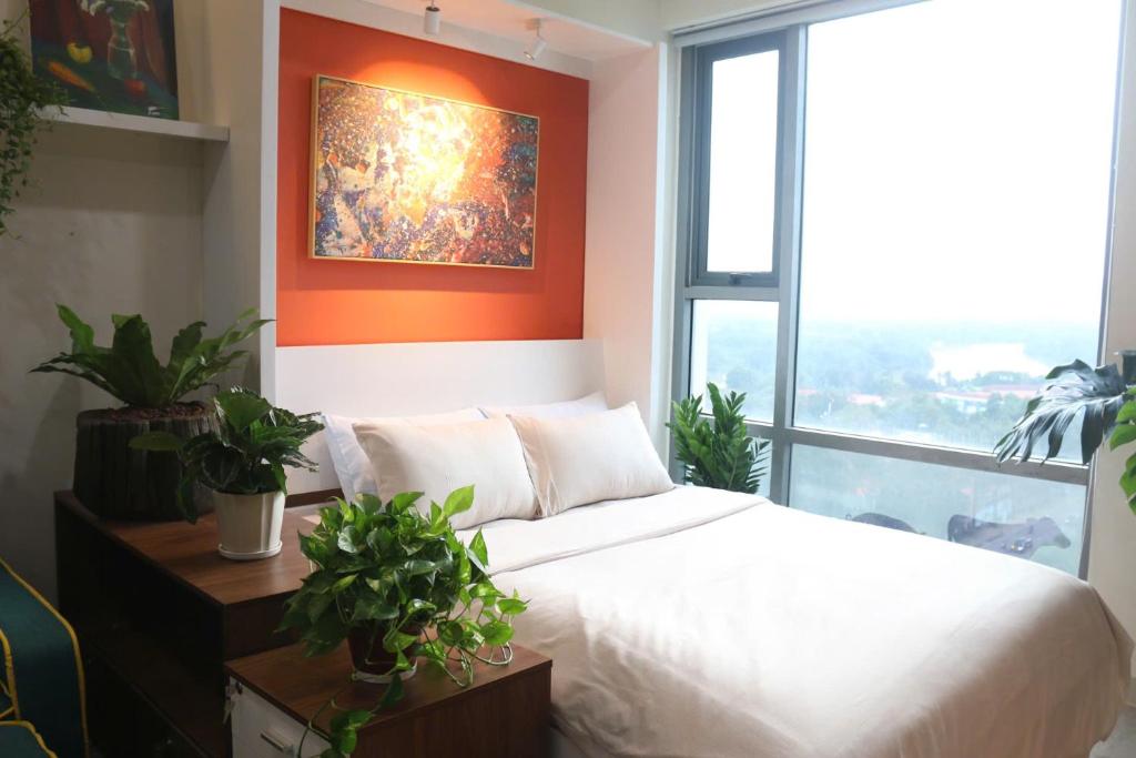 a bedroom with a white bed and a large window at Work & Rest Suite SECC in Ho Chi Minh City