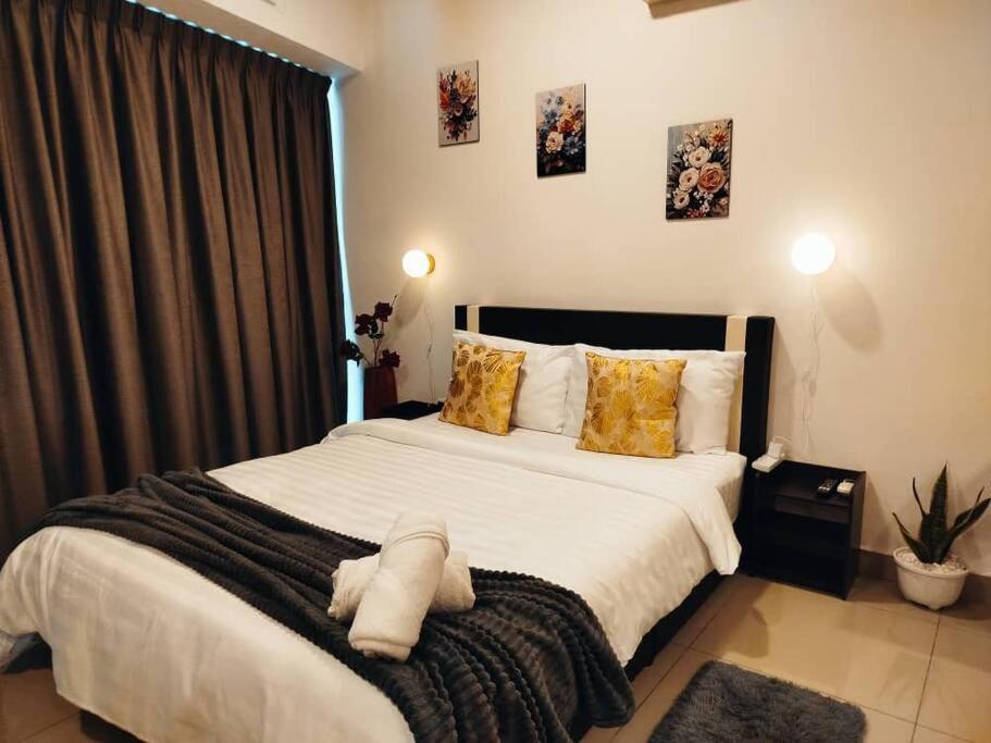 a bedroom with a large white bed with yellow pillows at Cozy Haven Perfect Studio Getaway in Petaling Jaya