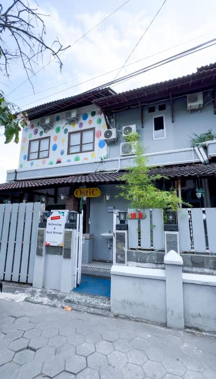un edificio bianco con un cancello davanti di OstiC House a Yogyakarta