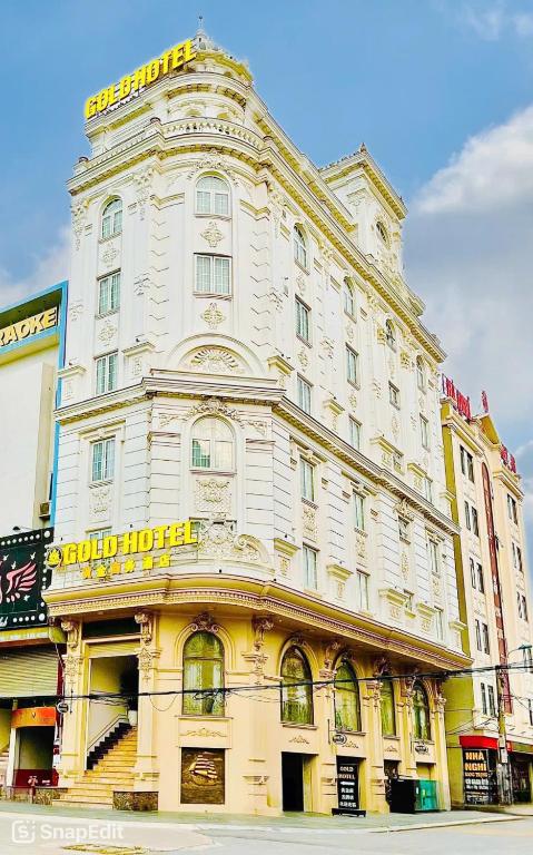 a large white building with a yellow sign on it at Gold Hotel Luxury - Tu Son in Phủ Từ Sơn